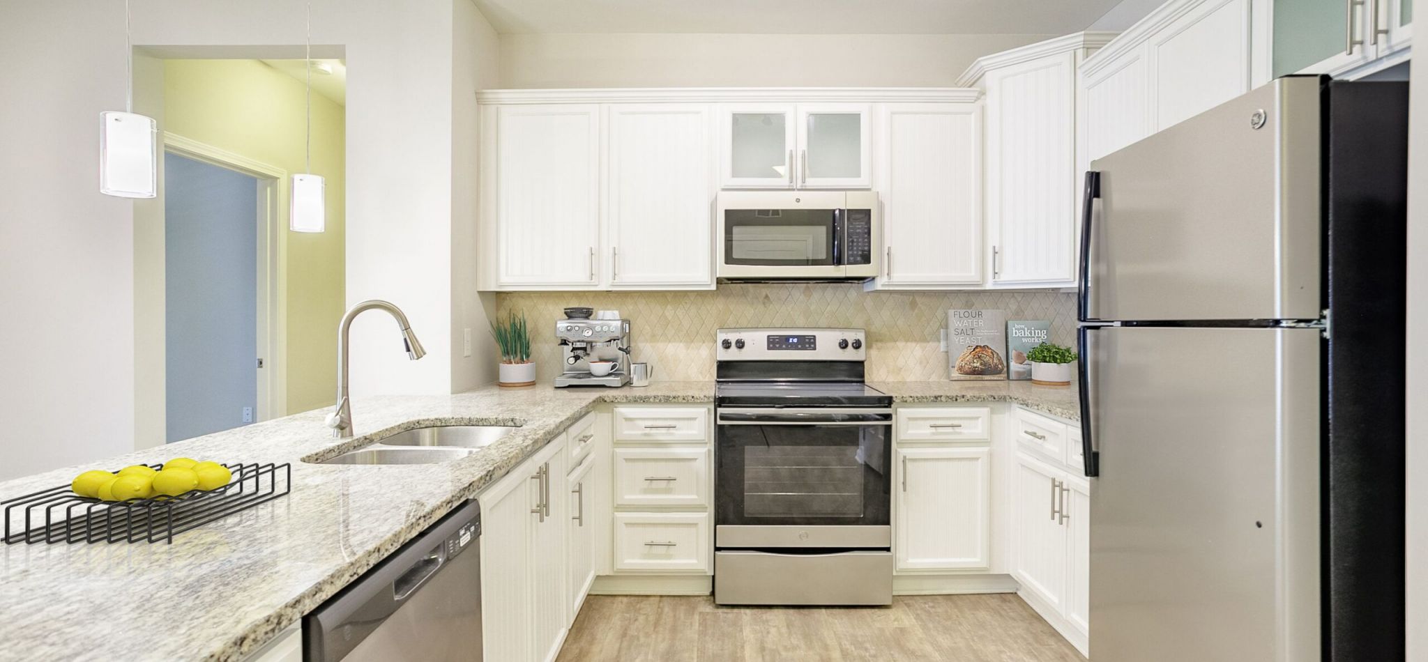 Hawthorne at Mirror Lakebeautiful apartment kitchen with granite countertops, dishwasher, and white cabinets